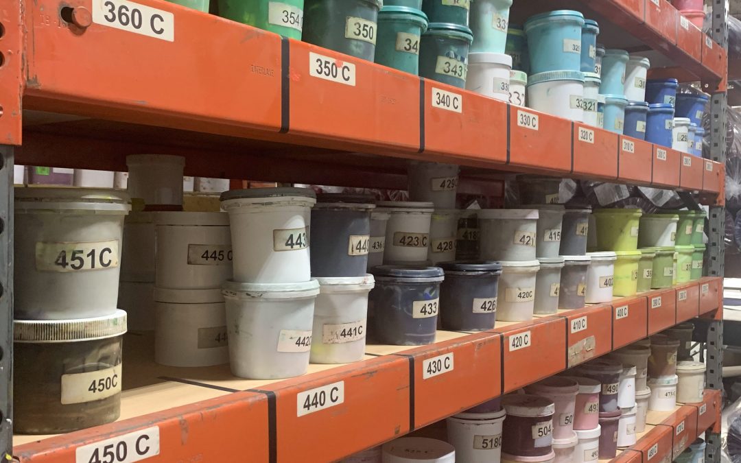 Industrial Shelves with cans of ink labeled with Pantone color codes